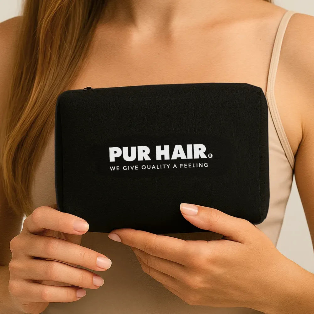 Frau hält PUR HAIR Travel Bag in schwarz mit weißem Logo in der Hand