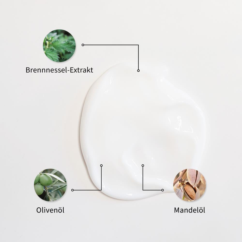 Weiße Creme-Textur mit markierten Inhaltsstoffen: Brennnessel-Extrakt, Olivenöl und Mandelöl.