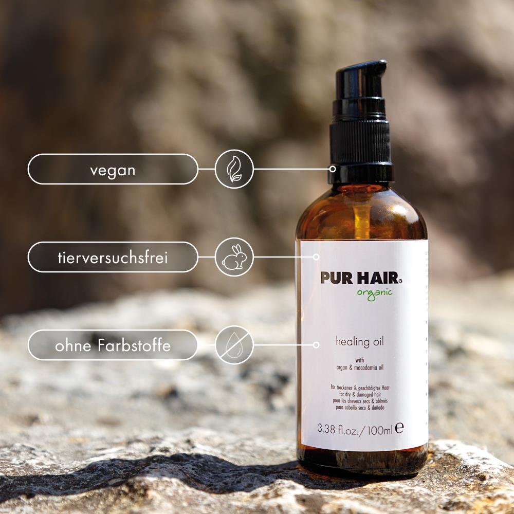 PUR HAIR Organic Healing Oil in brauner Glasflasche auf Steinoberfläche. Vegan, tierversuchsfrei und frei von Farbstoffen
