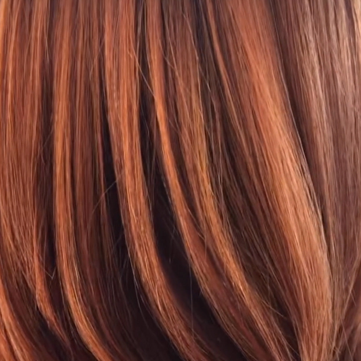 Gefärbtes rotes Haar, glatt und glänzend in der Struktur.