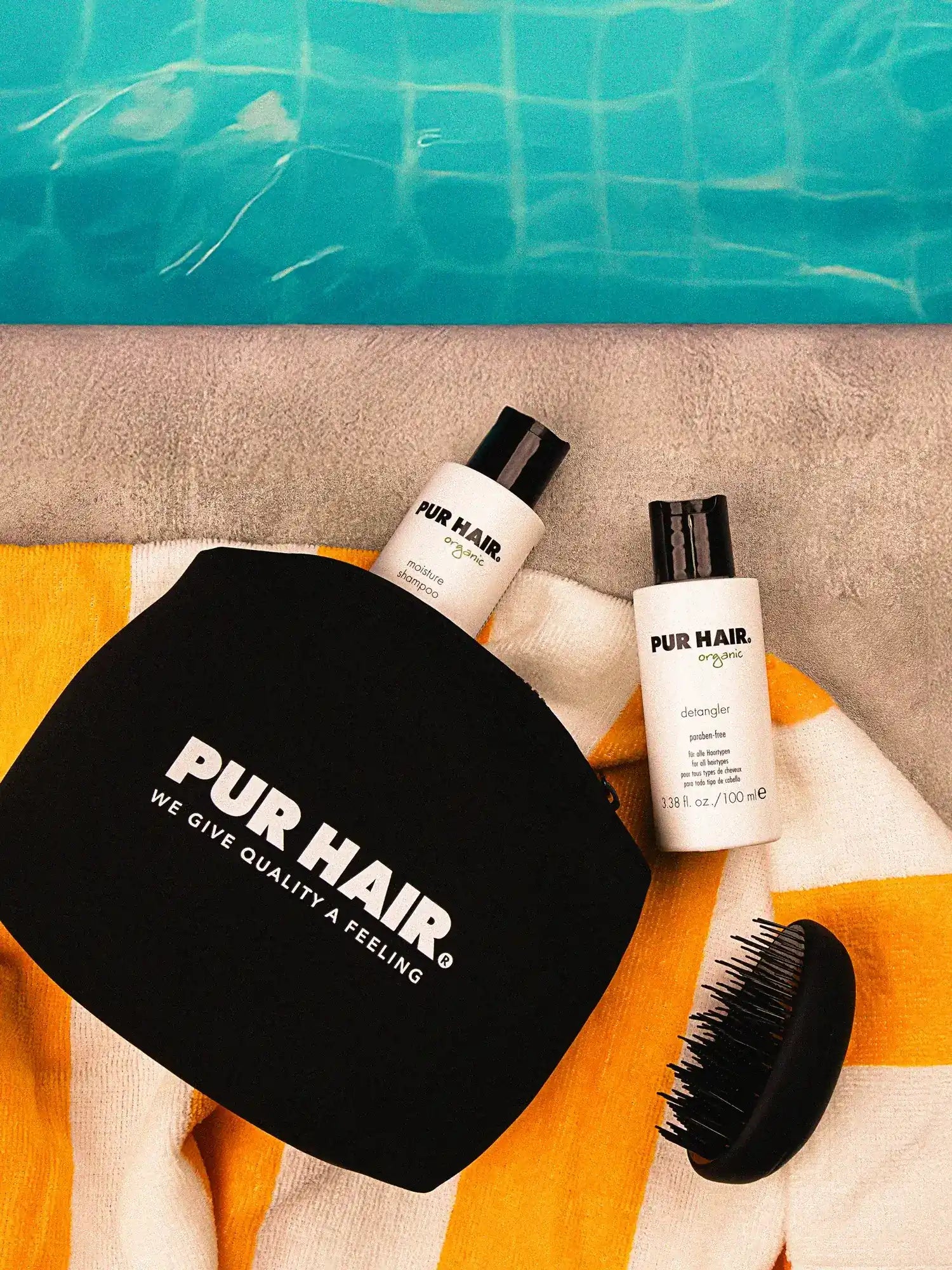 PUR HAIR Travel-Set mit Moisture Shampoo, Detangler, Tasche und Bürste auf Handtuch am Pool – perfektes Sommer-Haarpflege-Set für unterwegs