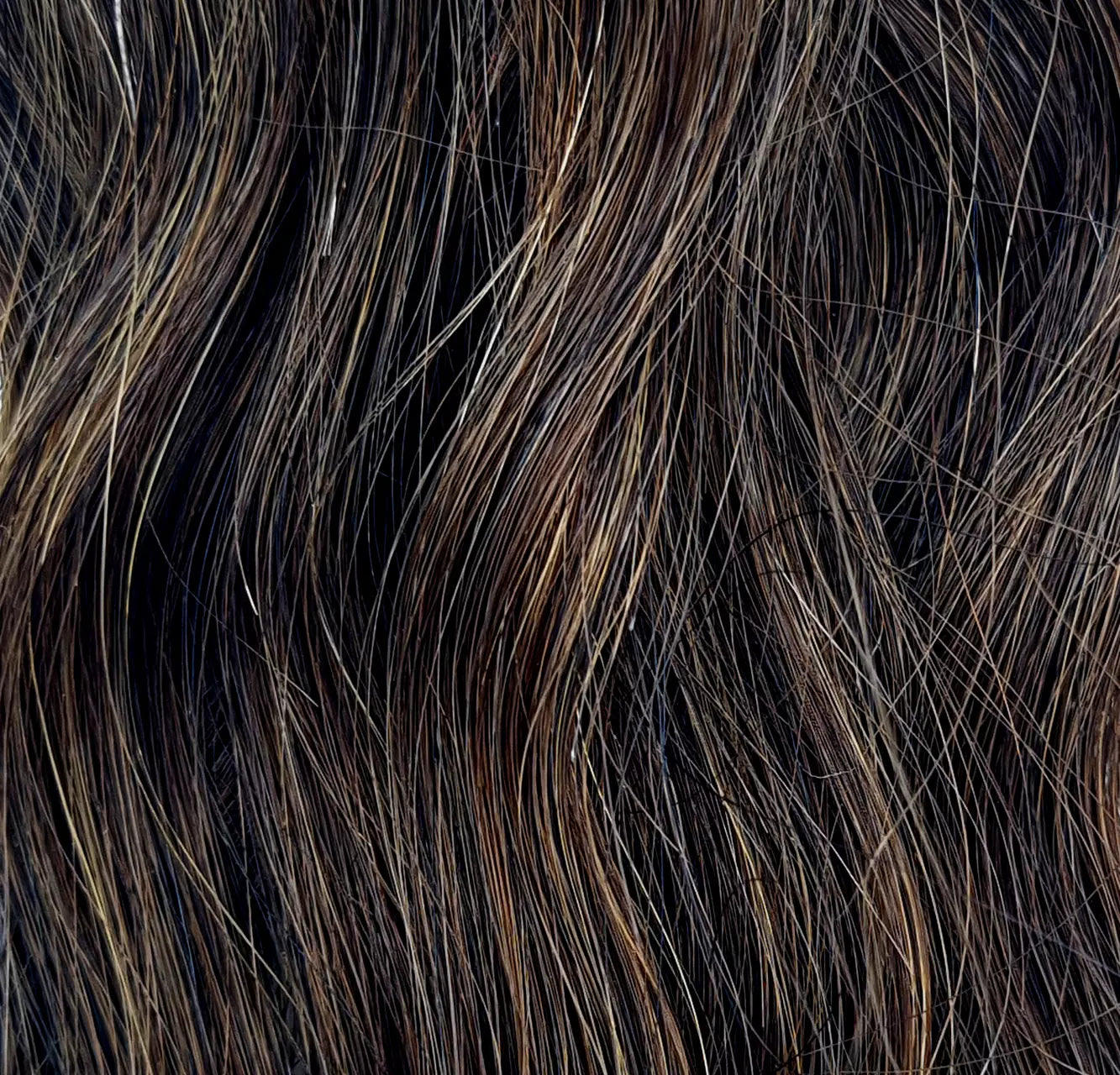 Detailaufnahme von dunkelbraunem Haar mit natürlicher Wellenstruktur – glänzend und voller Tiefe