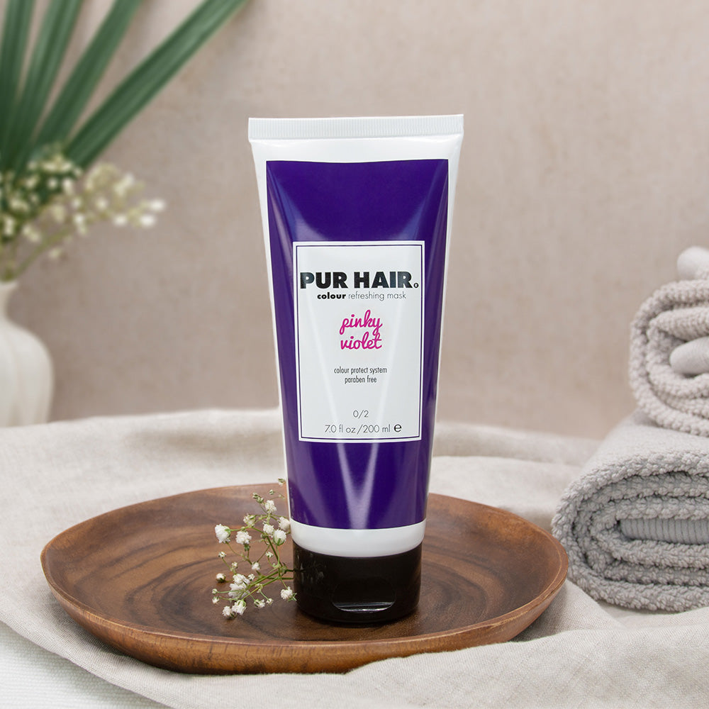 PUR HAIR Colour Refreshing Mask Piky Violet – Farbauffrischungsmaske für pinkes oder violettes Haar in 200 ml Tube, dekorativ auf Holzschale mit Handtuch und Pflanzendeko