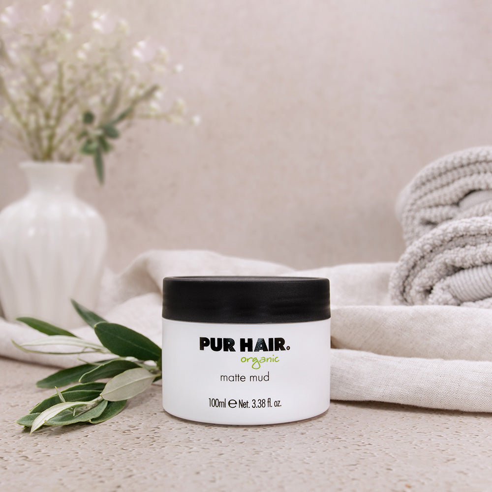 PUR HAIR Organic Matte Mud Haarstyling-Paste, 100 ml, dekorativ inszeniert mit Handtuch, Vase und Pflanzen für natürliche Pflege und Styling im Bad