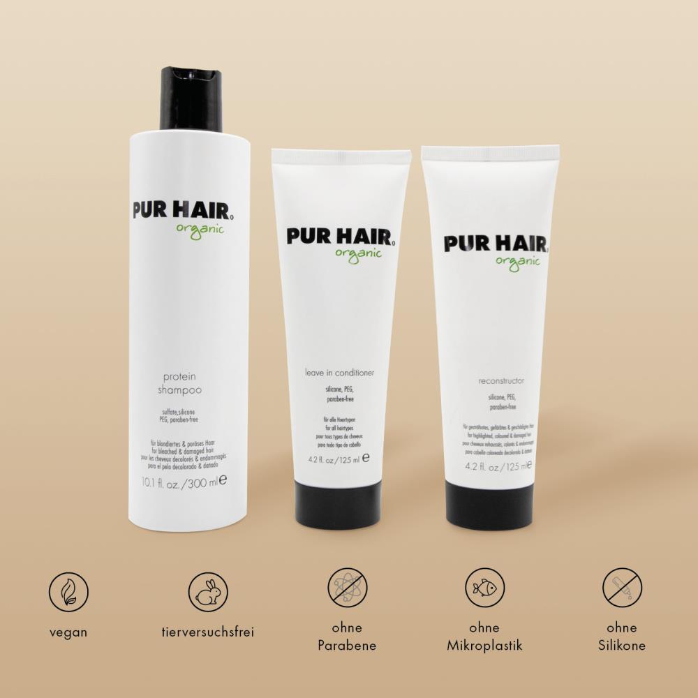 PUR HAIR Organic Haarpflege-Set: Protein Shampoo, Reconstructor und Leave In Conditioner vor braunem Hintergrund. Symbole für vegan, tierversuchsfrei, ohne Parabene, ohne Silikone und ohne Mikroplastik