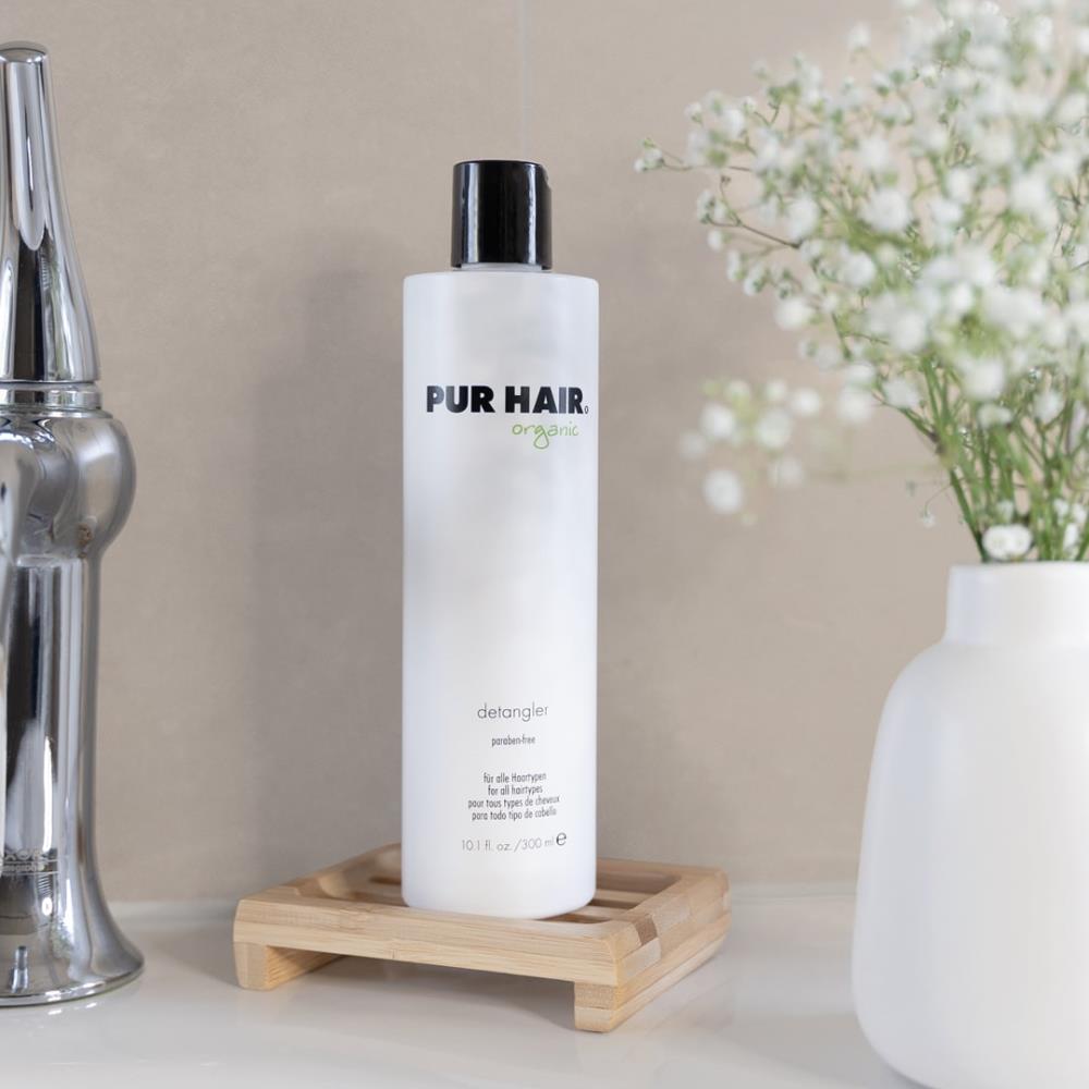PUR HAIR Organic Detangler 300 ml, Produktfoto im Badezimmer-Setting mit Vase und Blumen