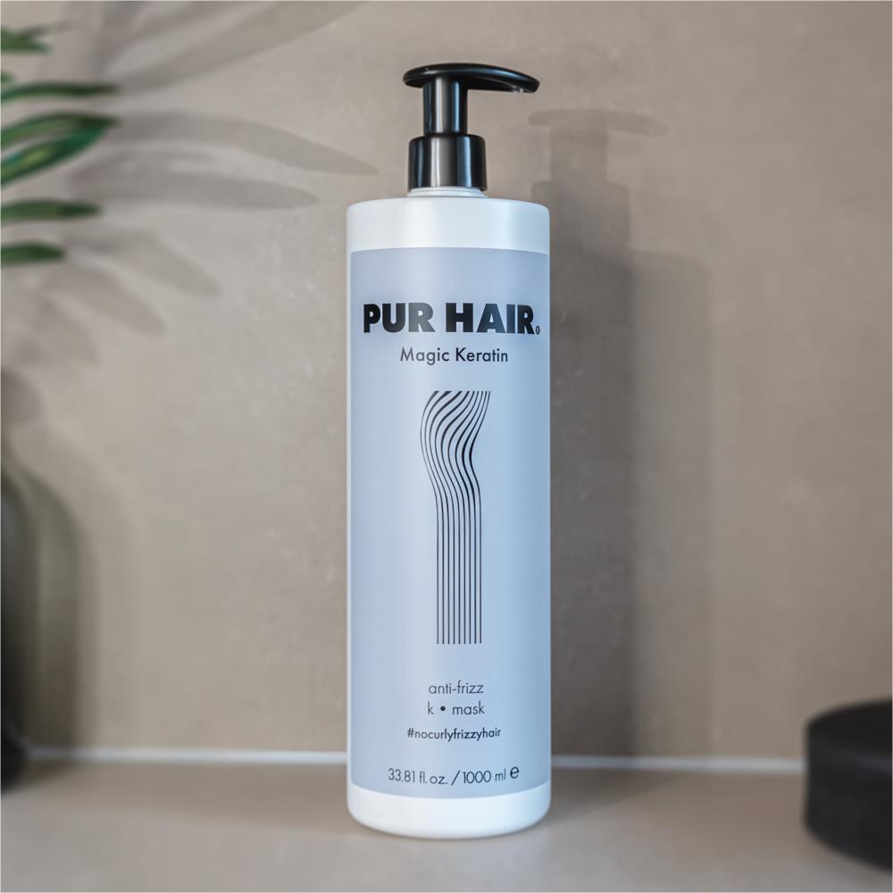PUR HAIR Magic Keratin Maske & Conditioner, 100 ml Flasche in hellblau mit schwarzem Pumpspender, dekorativ vor Steinwand platziert