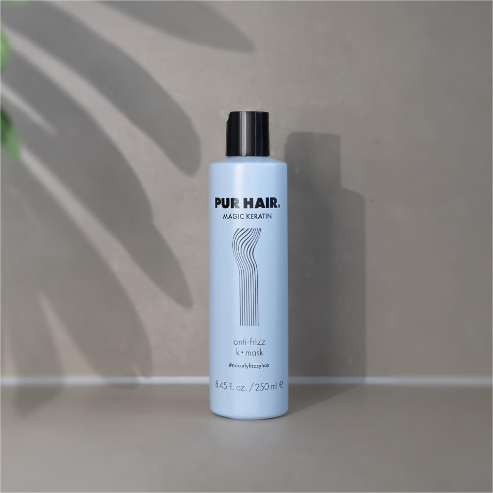 PUR HAIR Magic Keratin Maske & Conditioner, 250 ml Flasche in hellblau mit schwarzem Deckel, dekorativ vor Steinwand platziert