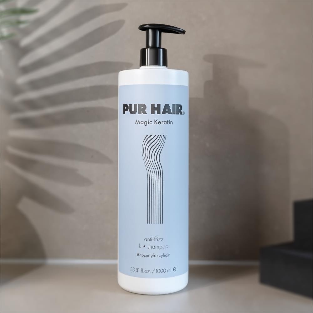 PUR HAIR Magic Keratin Shampoo, 1000 ml Flasche in hellblau mit schwarzem Pumpspender vor beigem Hintergrund