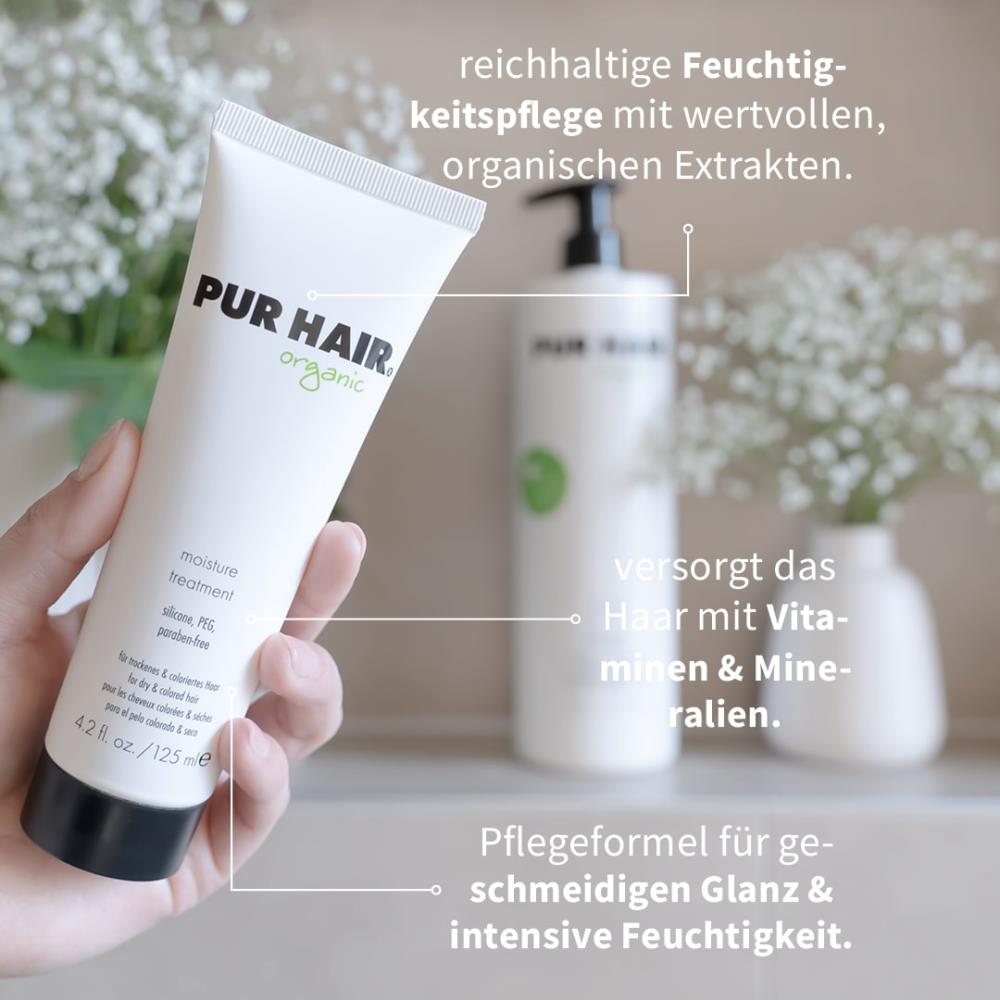 PUR HAIR Organic Moisture Treatment in 125 ml Tube wird in der Hand gehalten, im Hintergrund weiße Blüten und eine große Flasche; Text weist auf Feuchtigkeitspflege, Vitamine und Mineralien hin