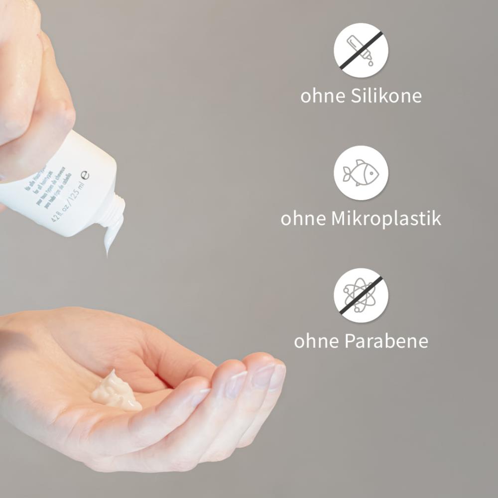 Hand drückt weißes Shampoo aus PUR HAIR Organic Tube, Produktmerkmale: ohne Silikone, Mikroplastik oder Parabene