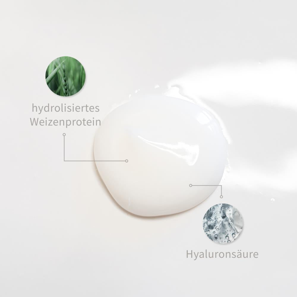 Weiße Creme-Textur mit markierten Inhaltsstoffen: Hydrolysiertes Weizenprotein, Hyaluronsäure