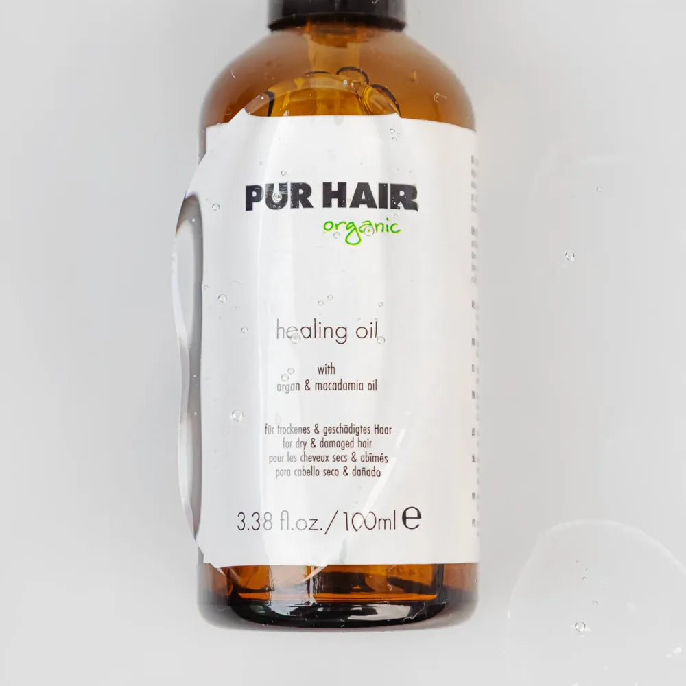 PUR HAIR Organic Healing Oil in brauner Glasflasche mit weißem Etikett und Wassertröpfchen – pflegendes Haaröl mit Argan- und Macadamiaöl für trockenes und geschädigtes Haar