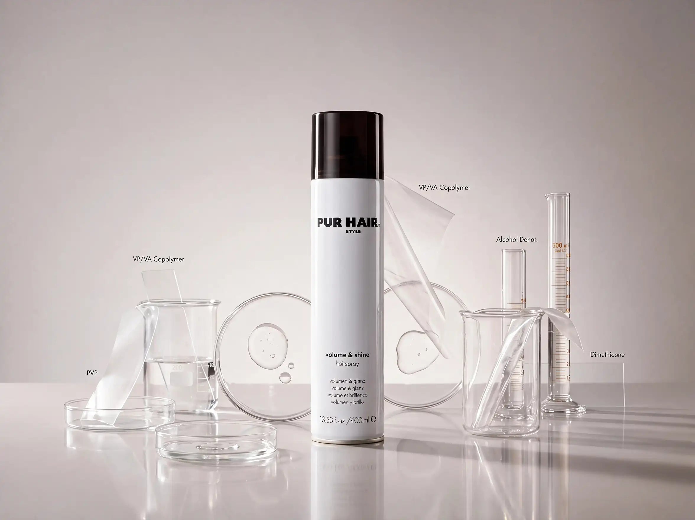 PUR HAIR Volume & Shine Haarspray zwischen Laborgefäßen mit Darstellung ausgewählter Inhaltsstoffe wie VP/VA Copolymer und Dimethicone.
