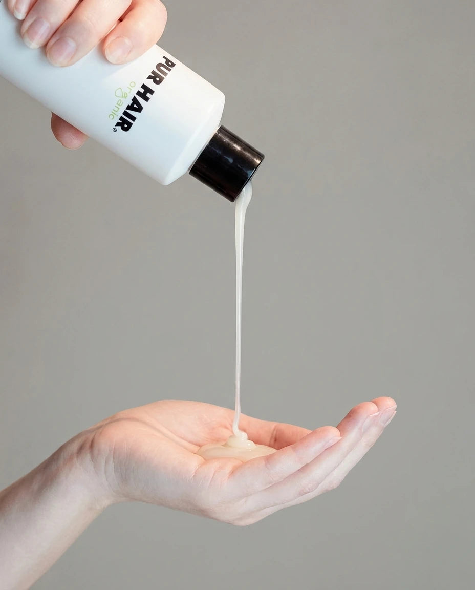 PUR HAIR Organic Shampoo wird in die Hand gegeben.