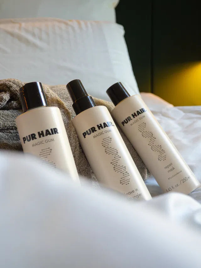 3 Magic Gum Flaschen liegen in einem weißen Hotelbett.